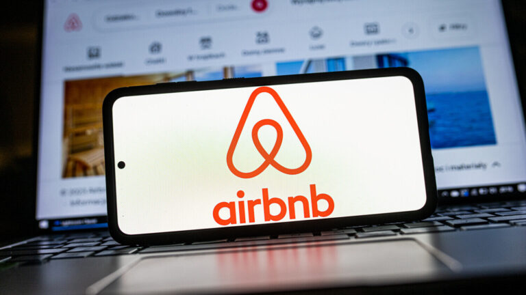 In this photo illustration an Airbnb logo seen displayed on